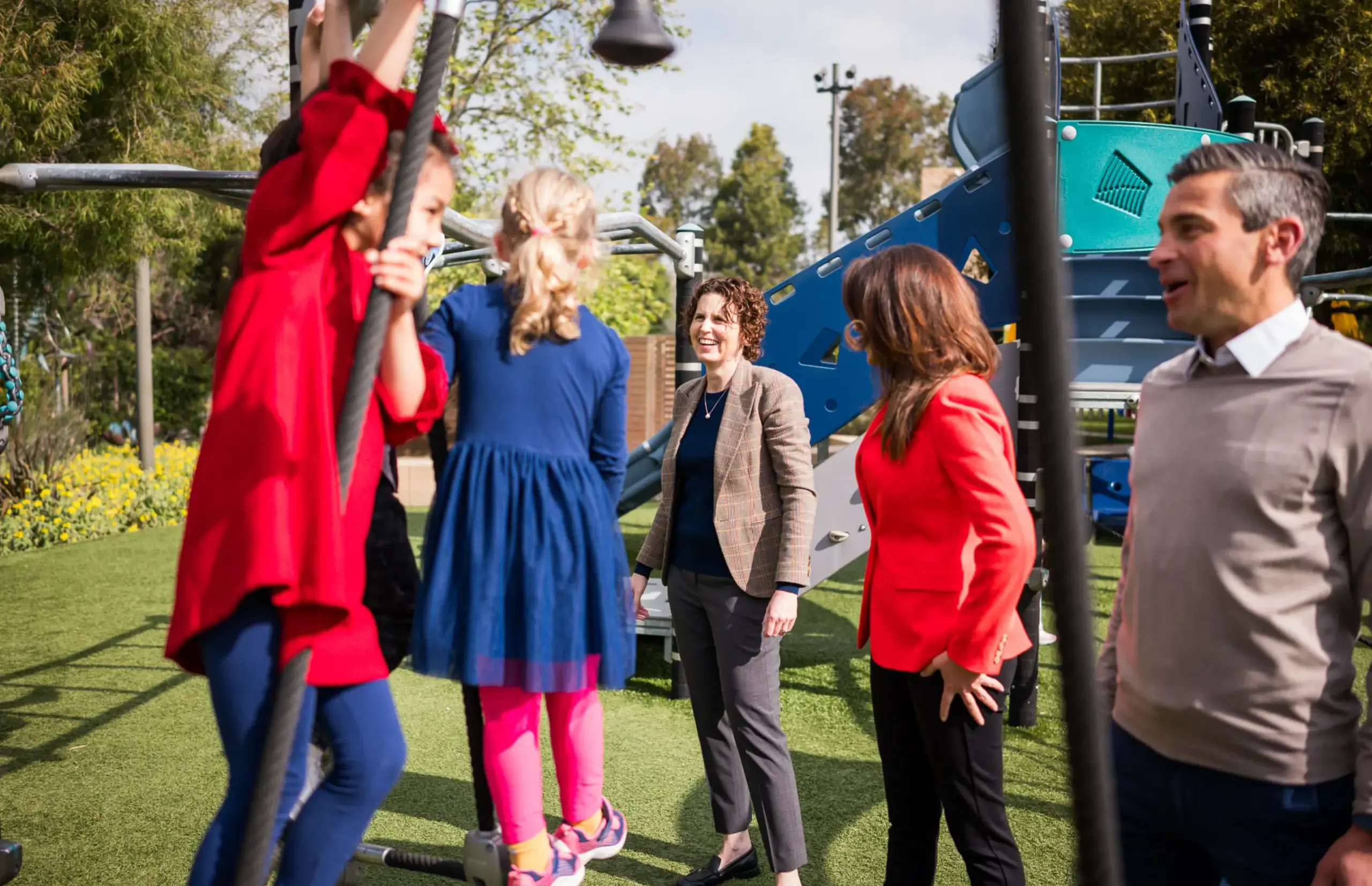 Leadership team members standing by playground equipment