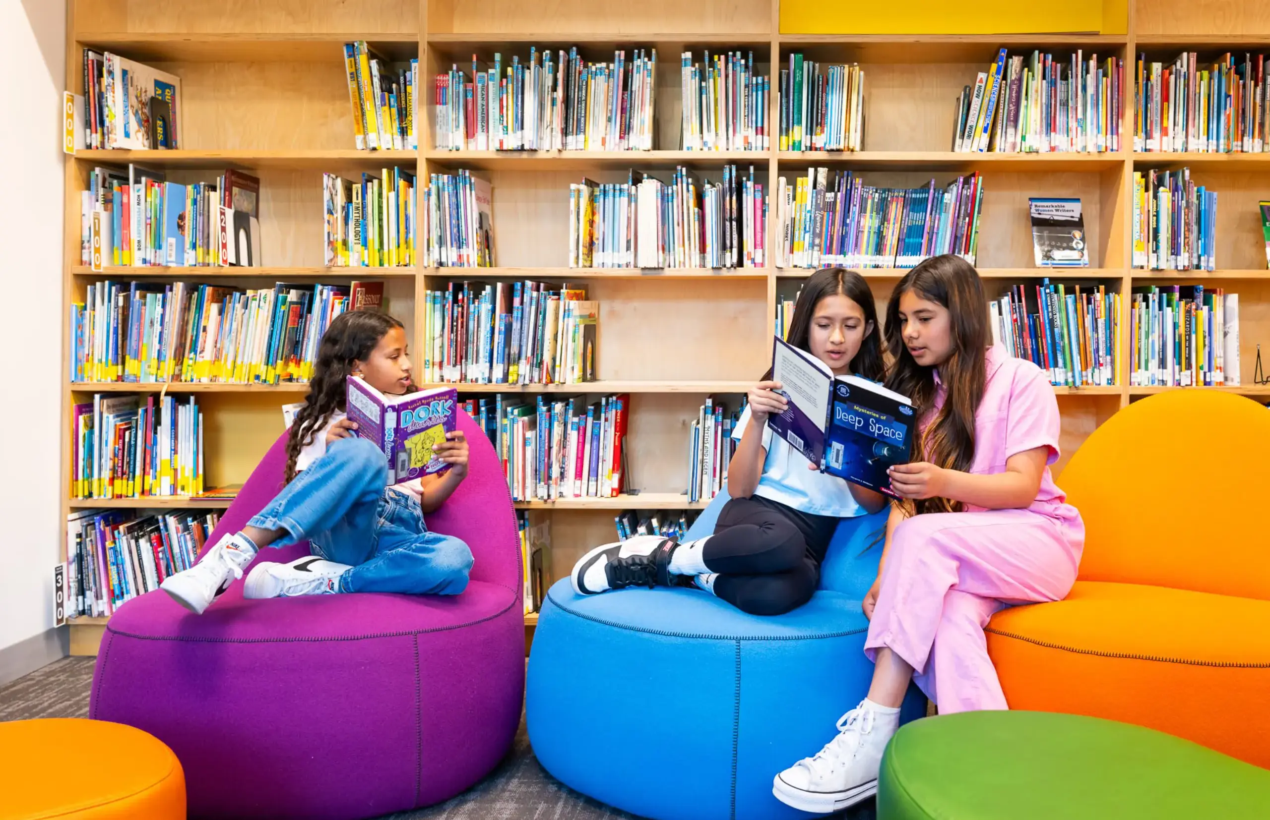 Students reading in library, sitting on beanbags