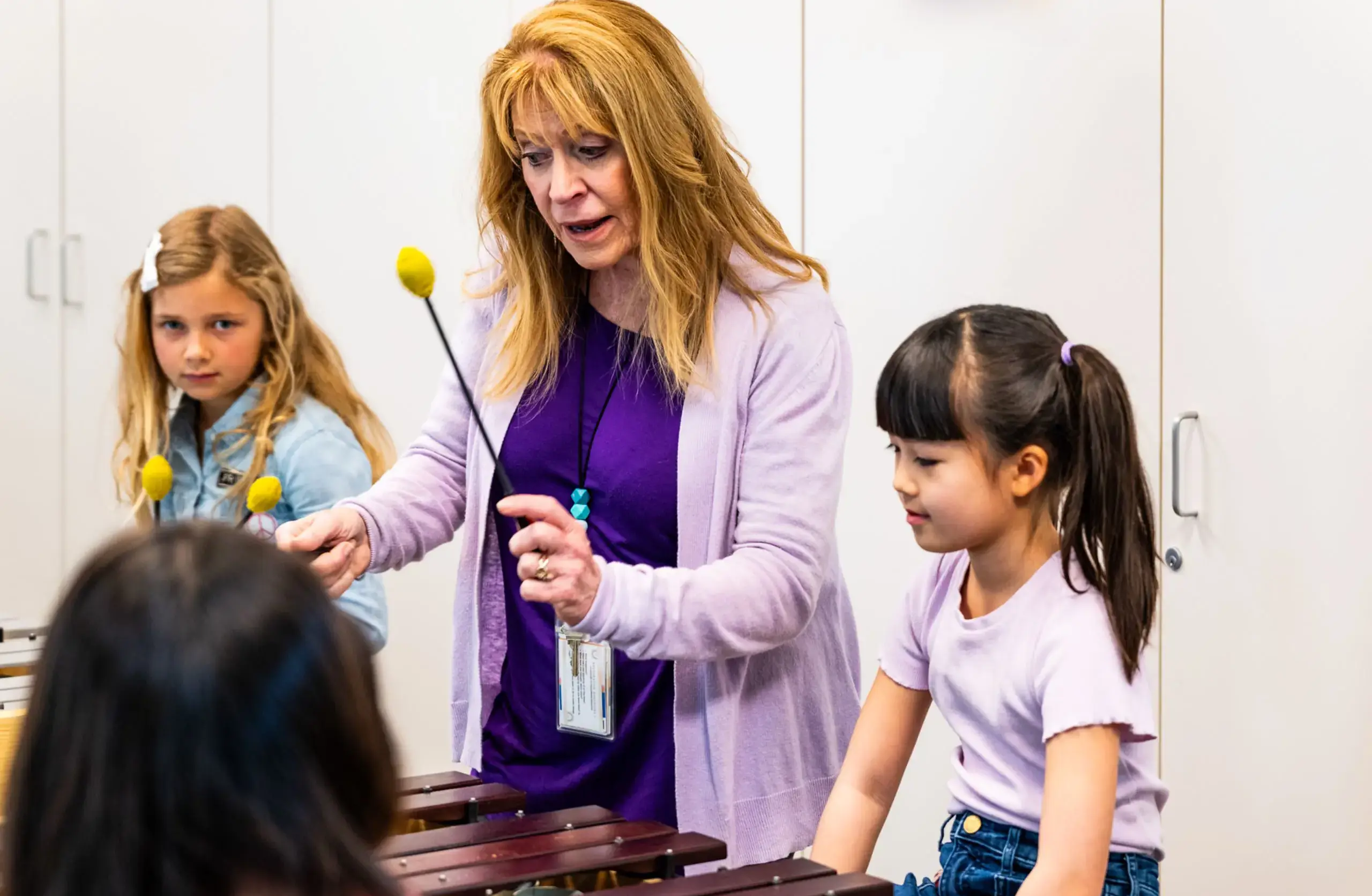 Music teacher and students playing xylophone