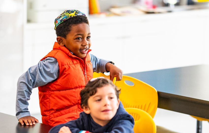 two lower school students sitting on chairs