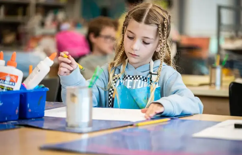 photography of Lower School student painting/creating art outside
