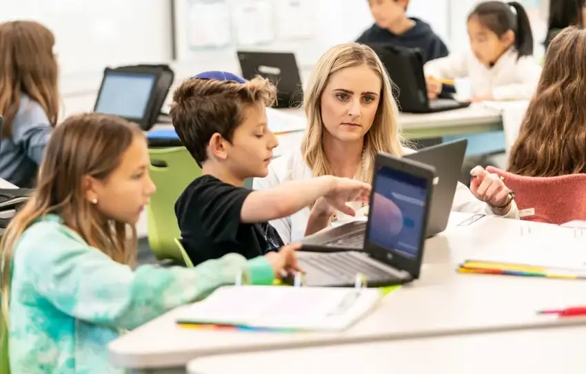 photography of Lower School mathematics team working at a whiteboard together