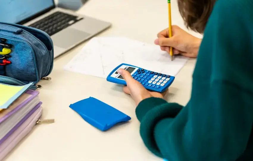 photography of Middle School students working at a desk on math problem