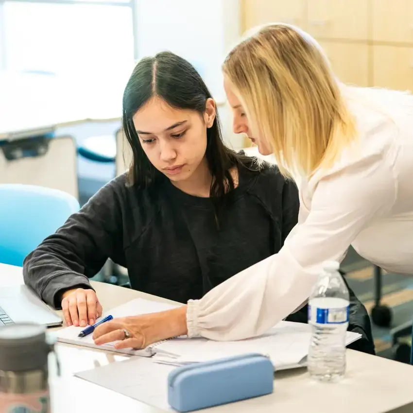 Teacher helping student in math lesson