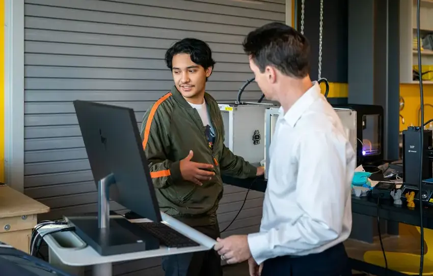 Upper school student with teacher in computer science lesson